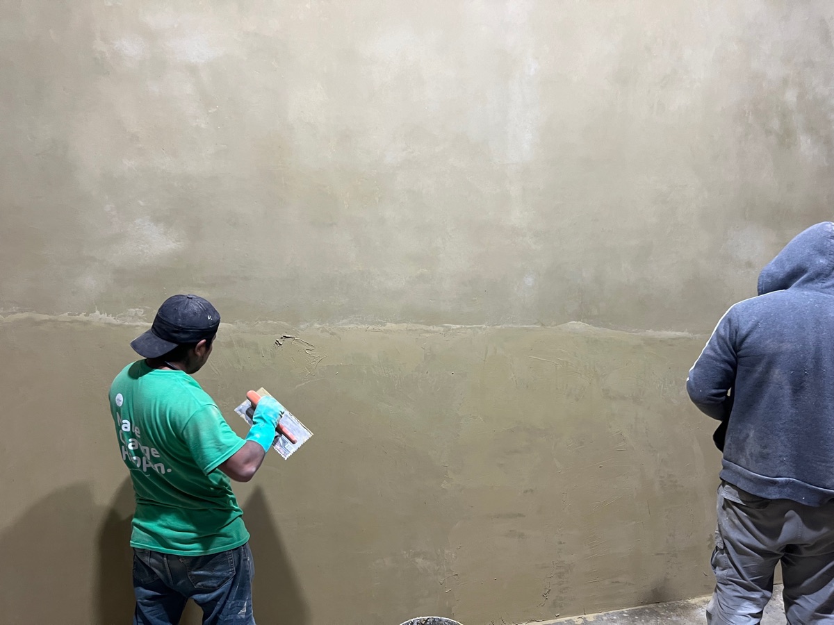 Trabajador aplanando y dando acabado a un muro.