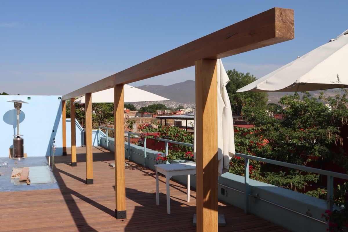 Pérgola de madera y piso de deck en una terraza.
